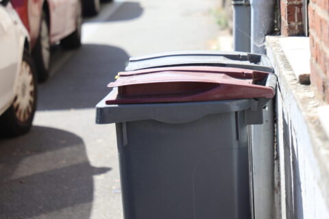 Image représentant une poubelle sur un trottoir de la ville