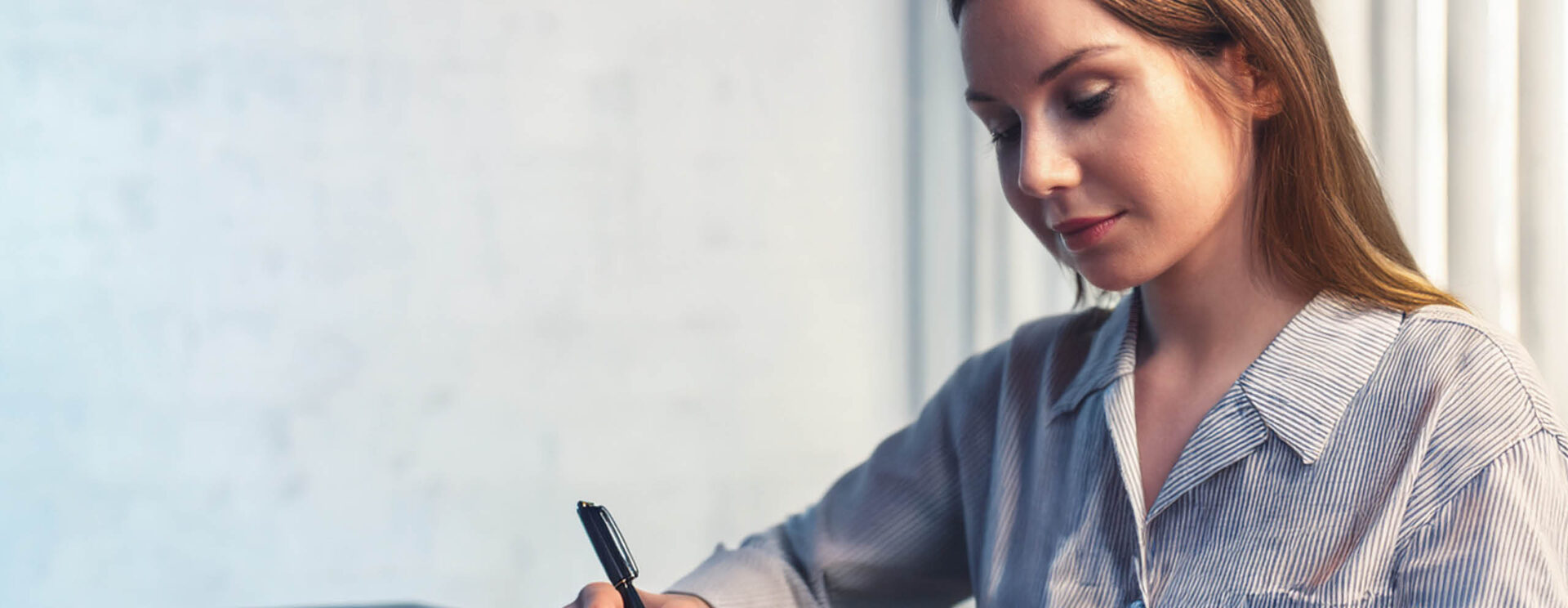 Une jeune femme qui rédige une lettre de motivation