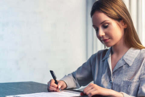 Une jeune femme qui rédige une lettre de motivation