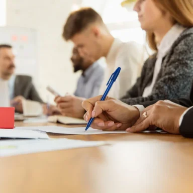 Image représentant des individus réunis autour d'une table et échangeant sur des dossiers