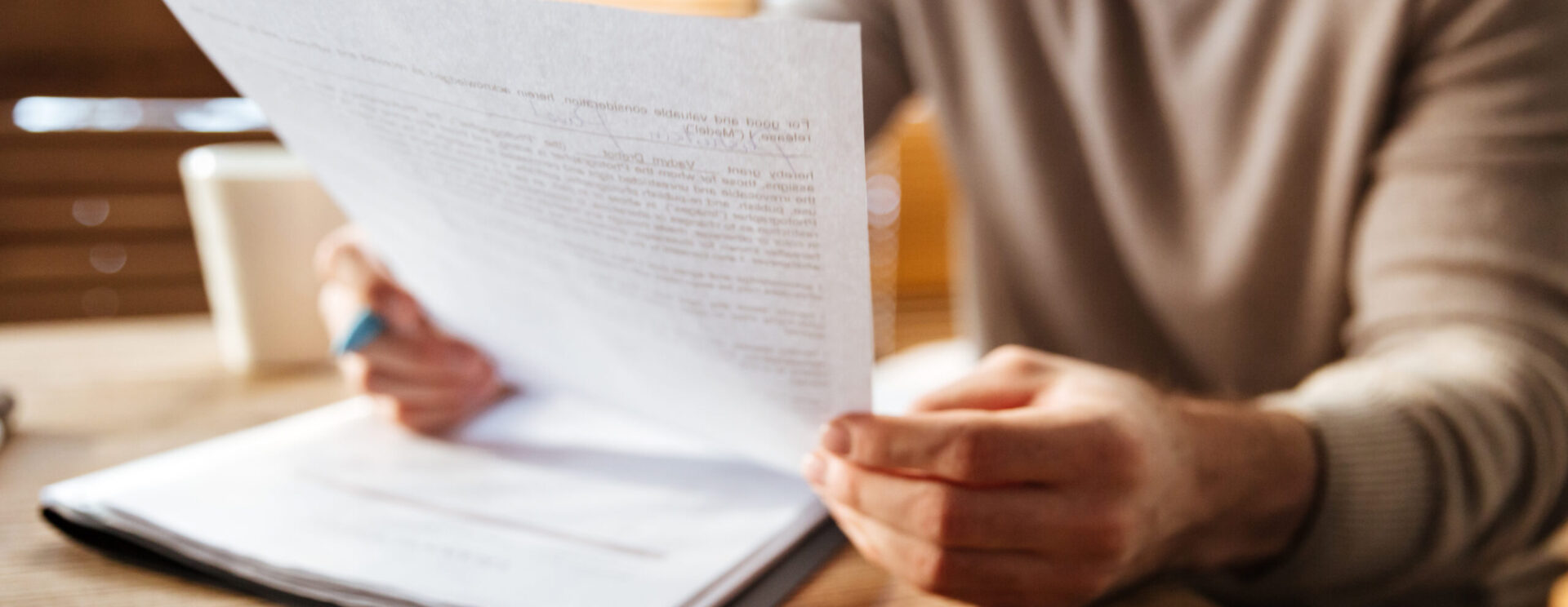 Image représentant un individu lisant une feuille sur un bureau