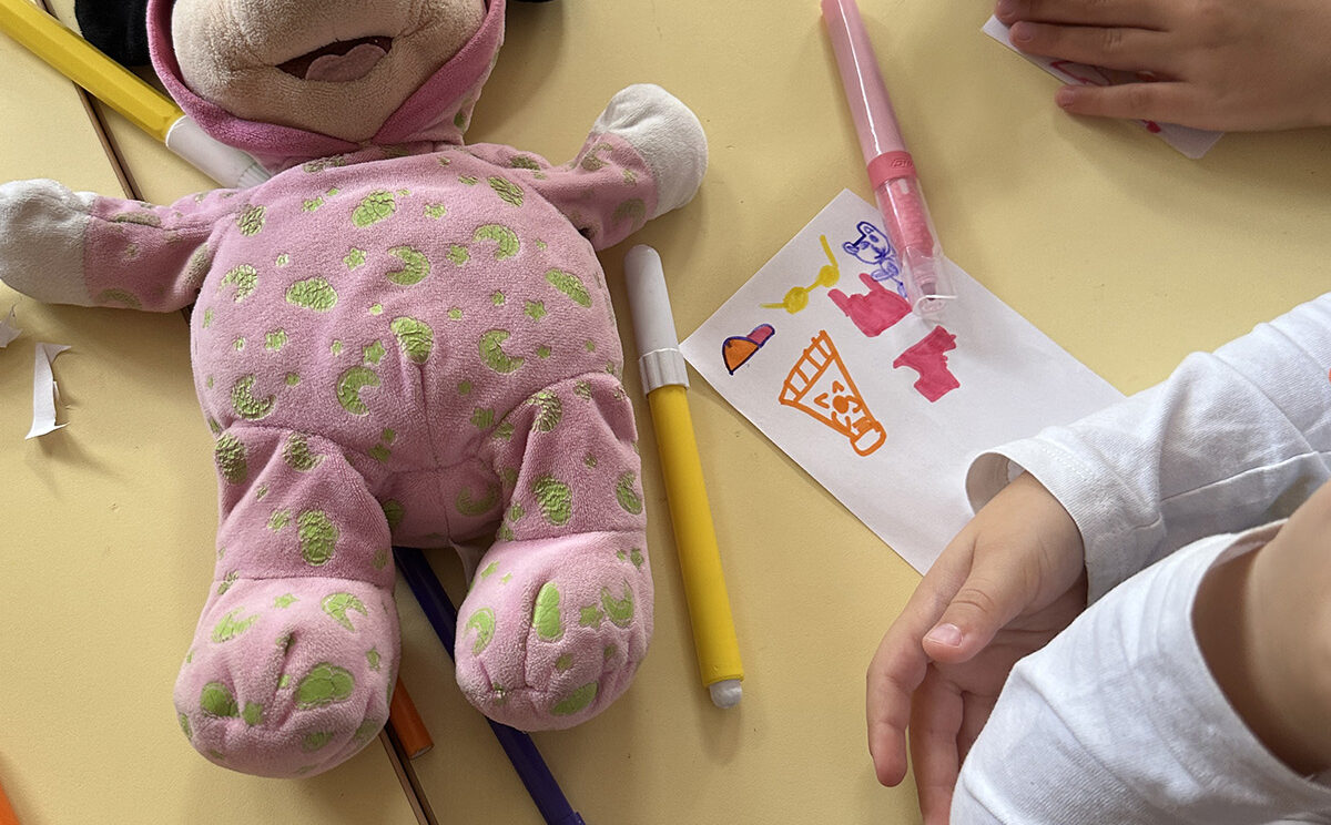 Photo d'une table avec une peluche et un dessin d'enfant