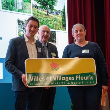 Image de la remise de la première fleur à la ville lors des récompenses du concours des villes et villages fleuris 2025
