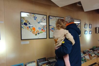 Image d'une personne de dos portant un enfant devant une exposition à la médiathèque Marguerite Yourcenar - Agrandir l'image, fenêtre modale