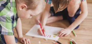 photo illustrant des enfants dessinant sur une feuille de papier blanc